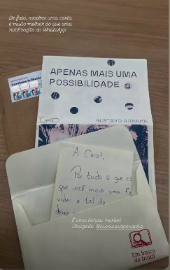 Carta e libreto 'Apenas mais uma possibilidade' sobre a mesa, com envelope aberto e bilhete escrito à mão